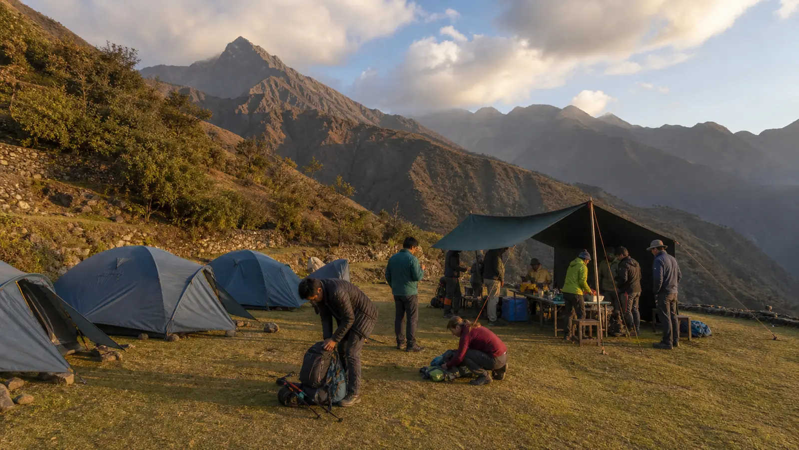 Guides and hikers organizing a clean official Inca Trail campsite at sunset