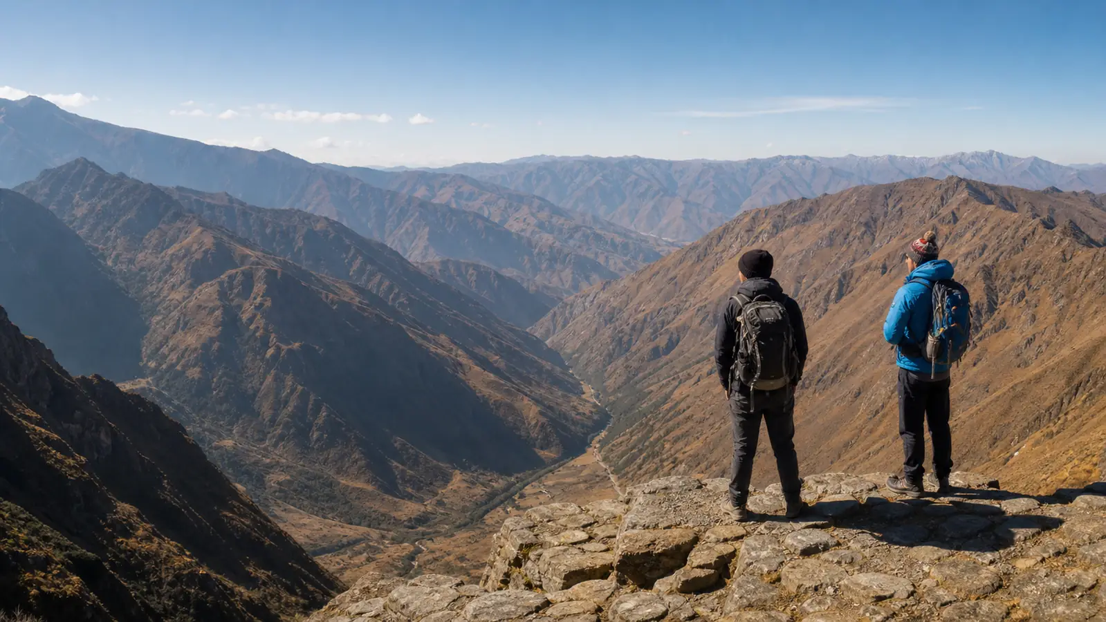 Hikers viewing distant Andean ridges under clear August skies